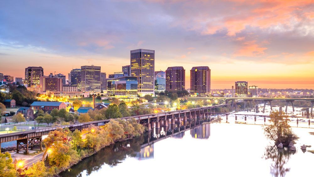 An aerial view of a city skyline over a river at sunset.