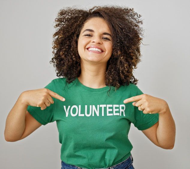 A woman wearing a green shirt that says volunteer