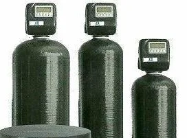 two black water filters are sitting next to each other on a white brick wall .