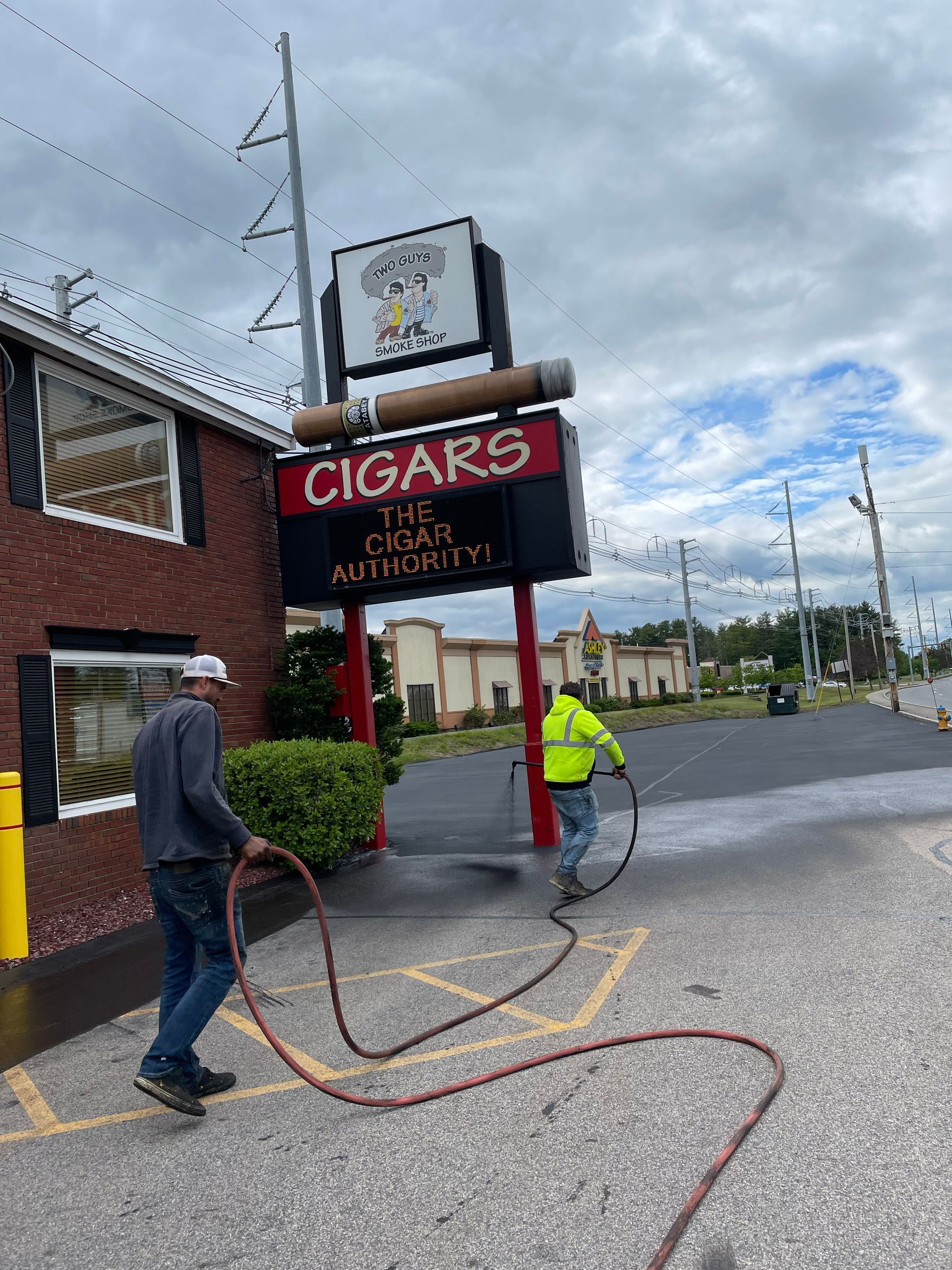 Two workers with a hose near a 