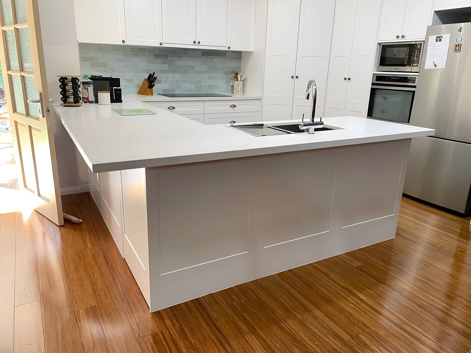 Bright Modern Kitchen Featuring a Large White Island — Piscopo Kitchens Plus In Forster, NSW