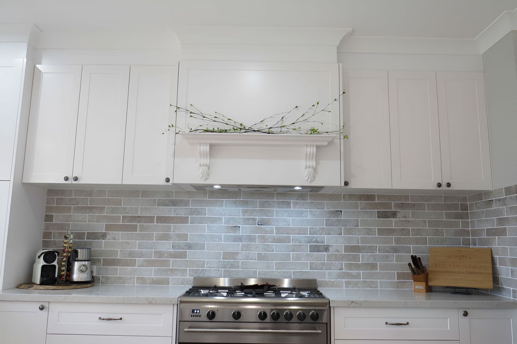 Kitchen With White Cabinets and Grey Brick Backsplash — Piscopo Kitchens Plus In Forster, NSW