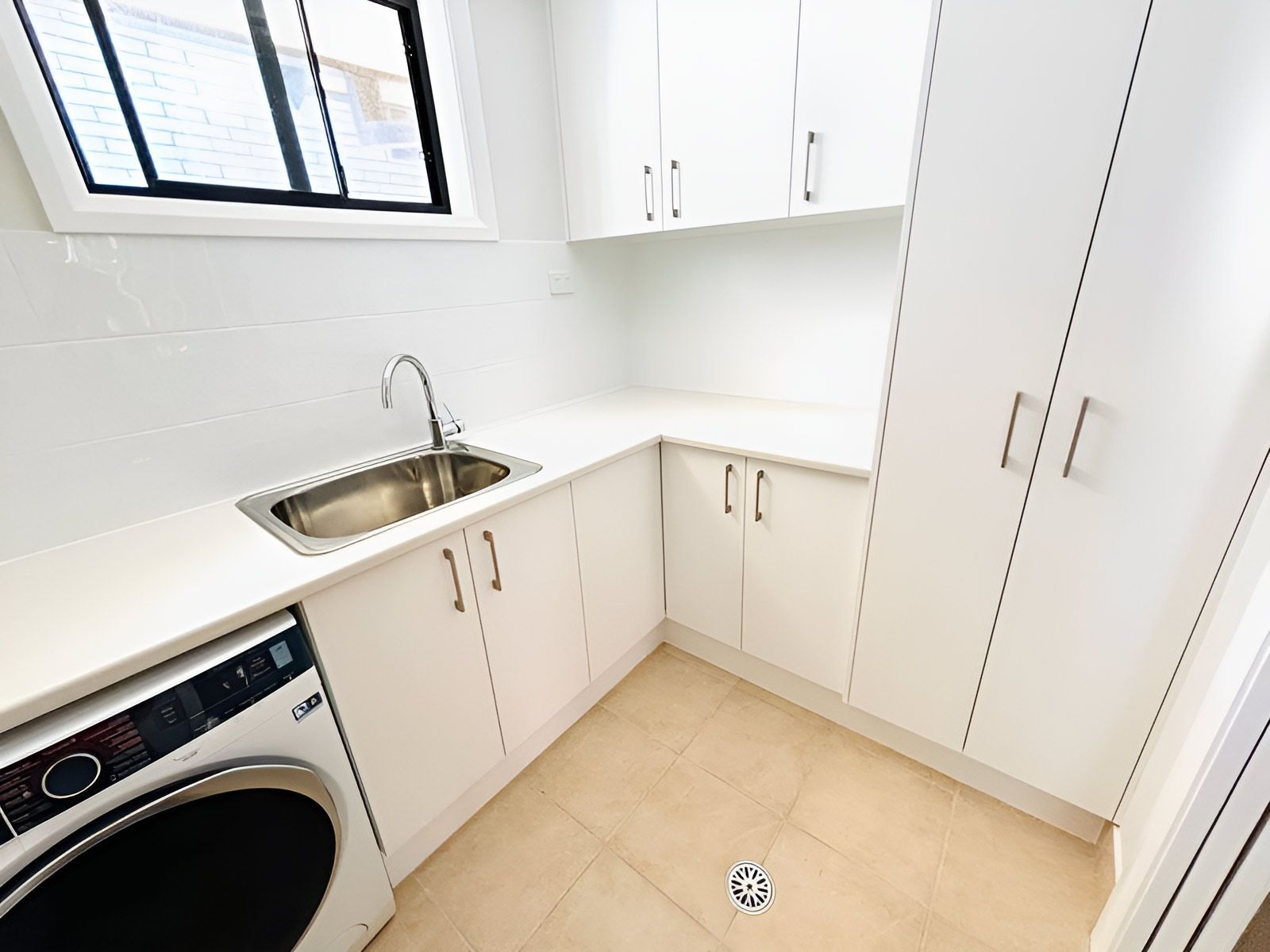Laundry Room With White Cabinets and a Washing Machine — Piscopo Kitchens Plus In Smiths Lake, NSW