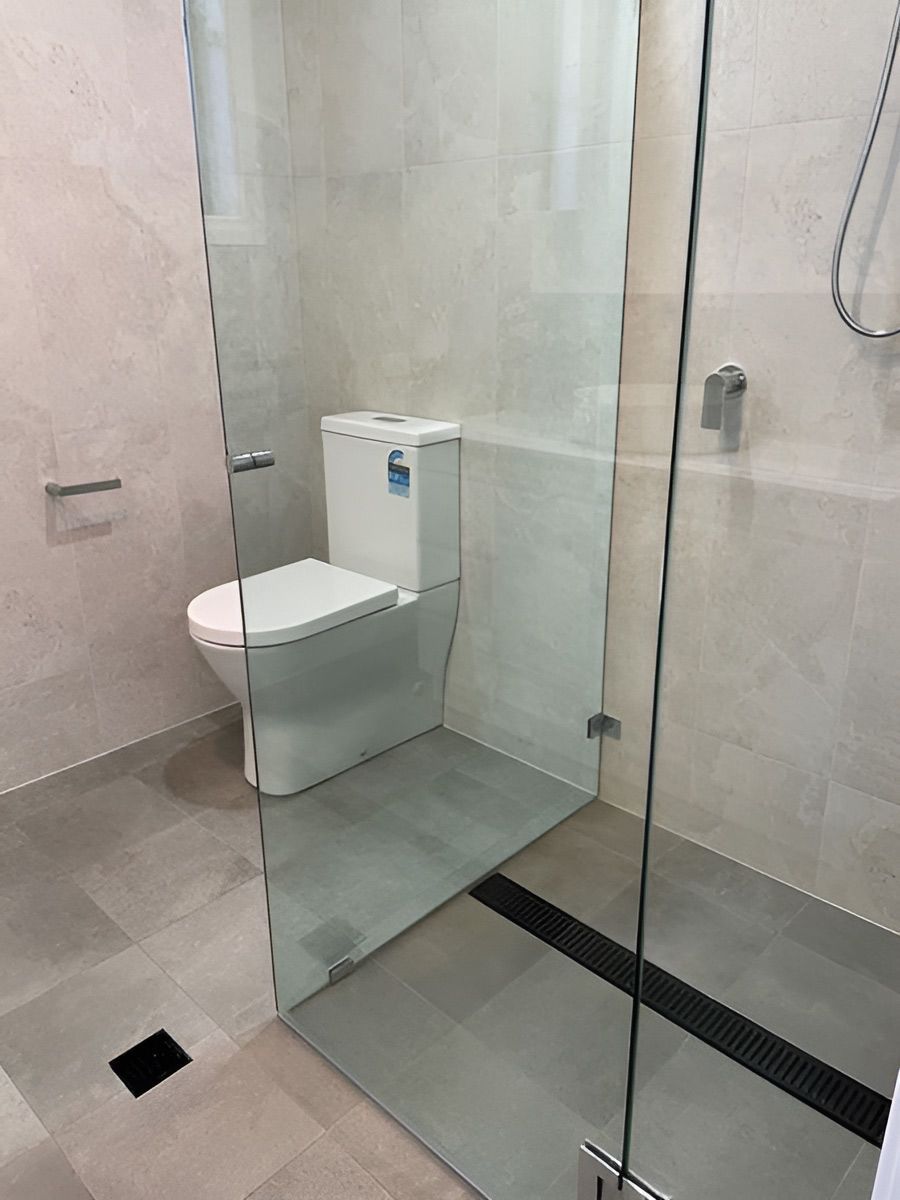 Bathroom With Light Beige Tiled Walls and Grey Tiled Floor — Piscopo Kitchens Plus In Forster, NSW