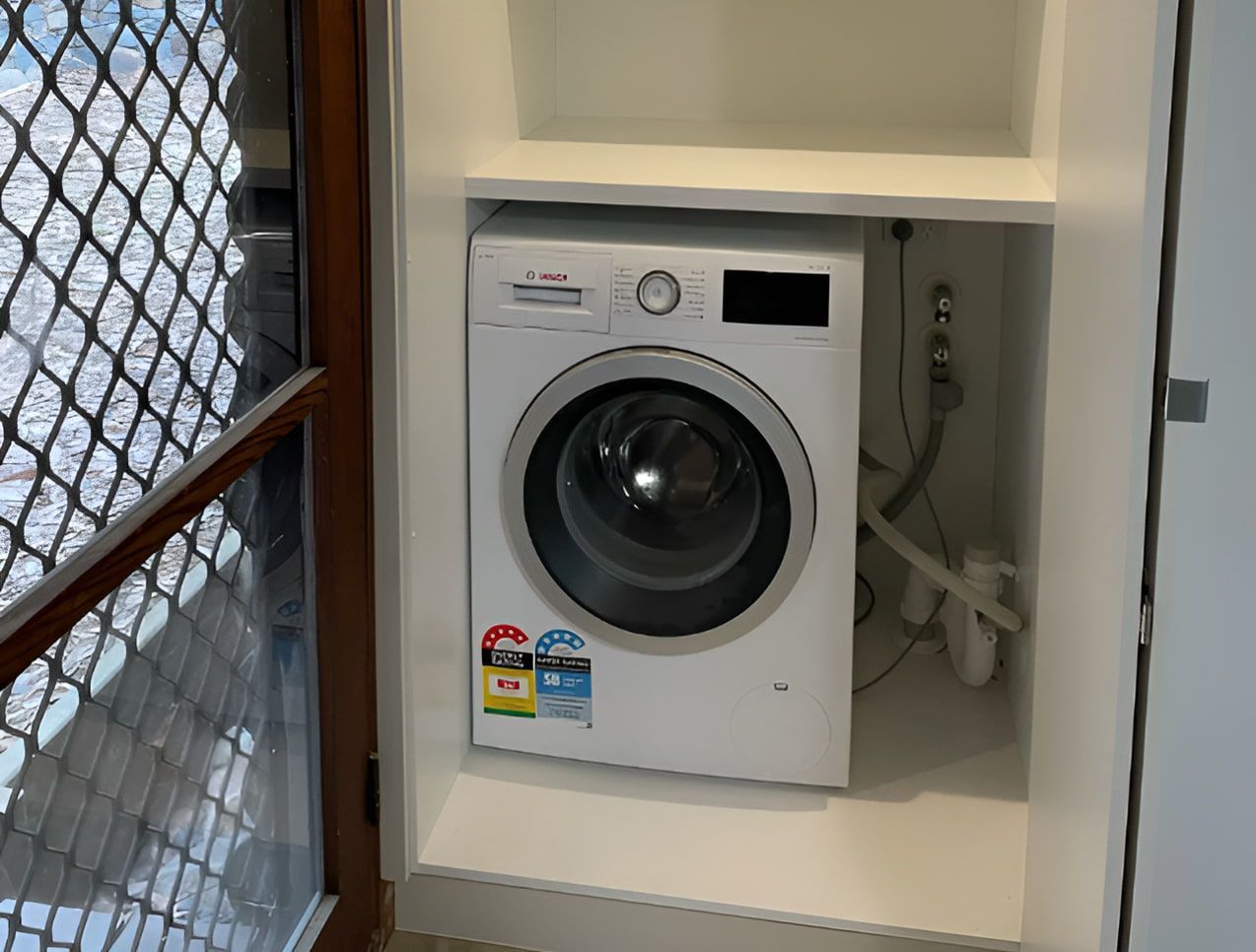 A Washing Machine in a White Cabinet — Piscopo Kitchens Plus In Forster, NSW