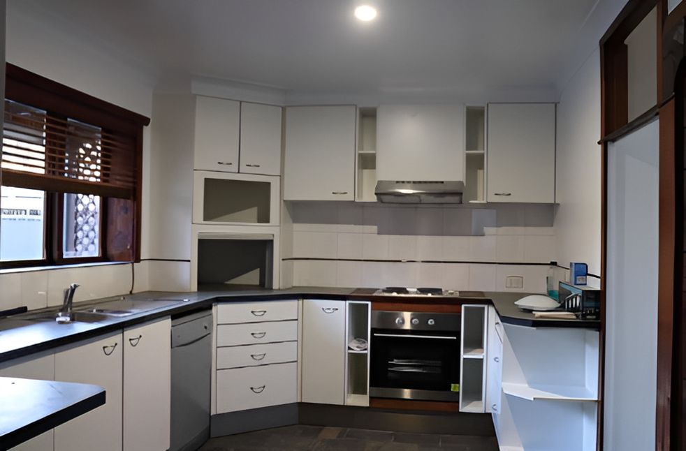 An Empty Kitchen With White Cabinets — Piscopo Kitchens Plus In Smiths Lake, NSW