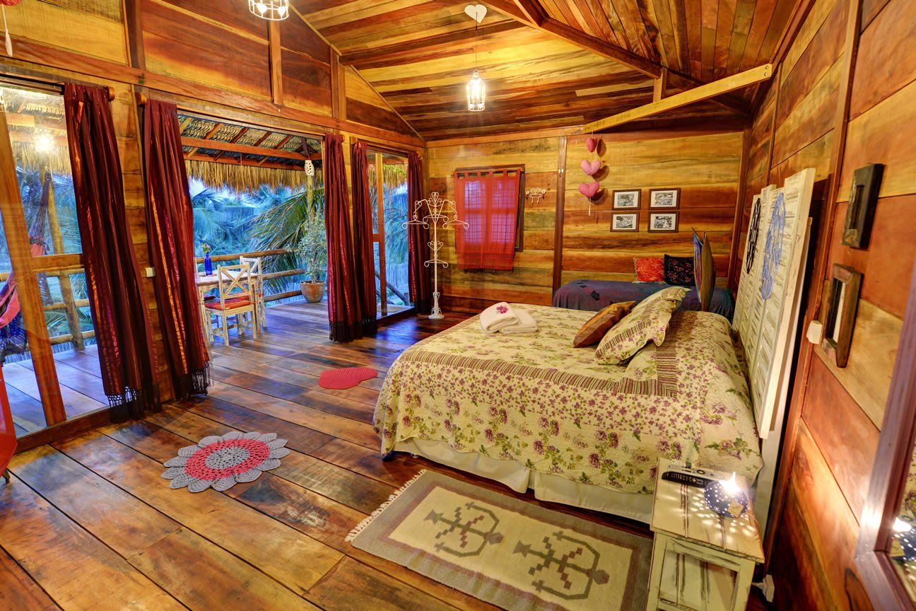 Um quarto em uma cabana de madeira com uma cama grande.