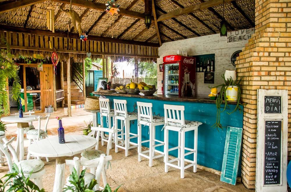 Um restaurante com mesas e cadeiras e um bar azul.