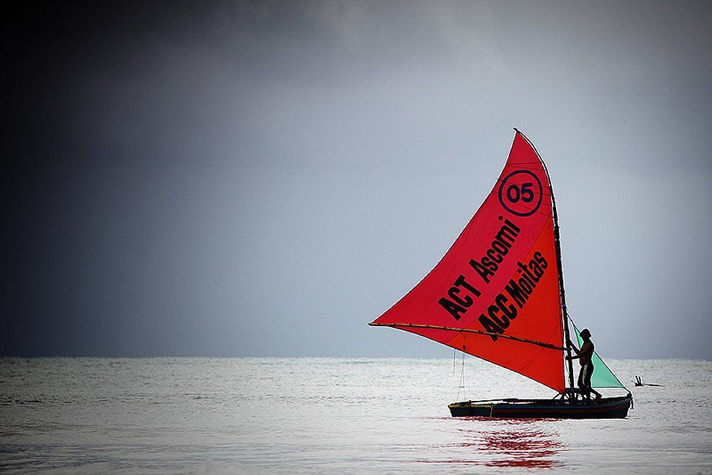 Um veleiro vermelho com o número 65 nele