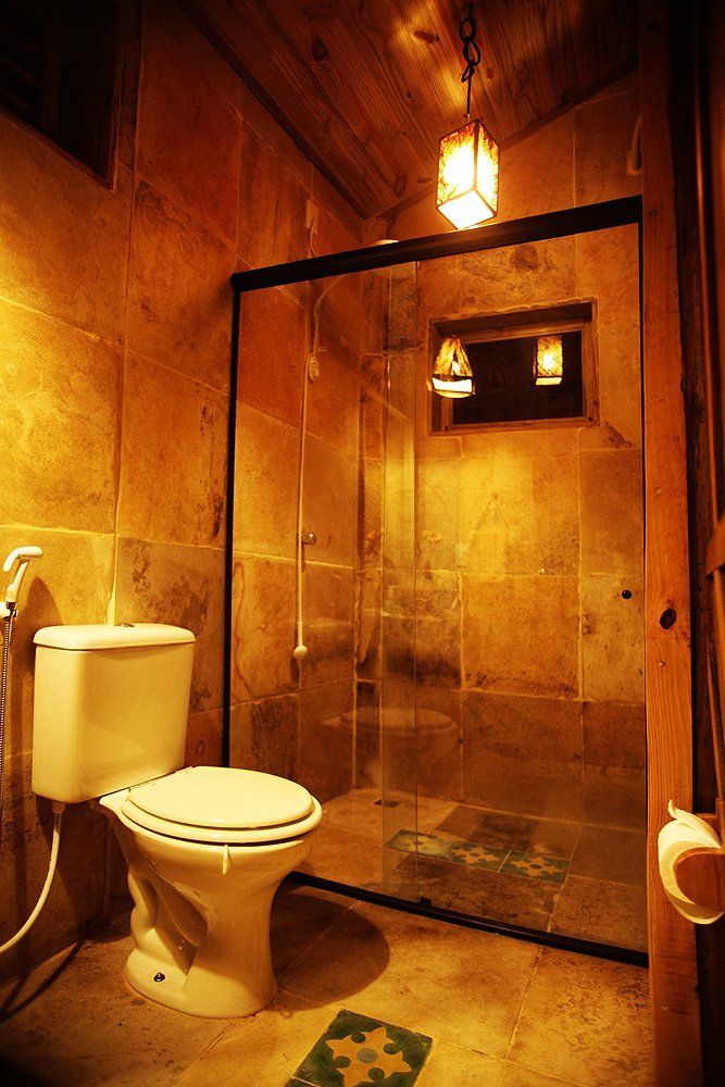 Um banheiro com vaso sanitário e chuveiro.