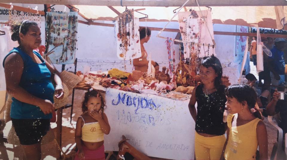 Um grupo de pessoas em pé ao redor de uma mesa que diz medida