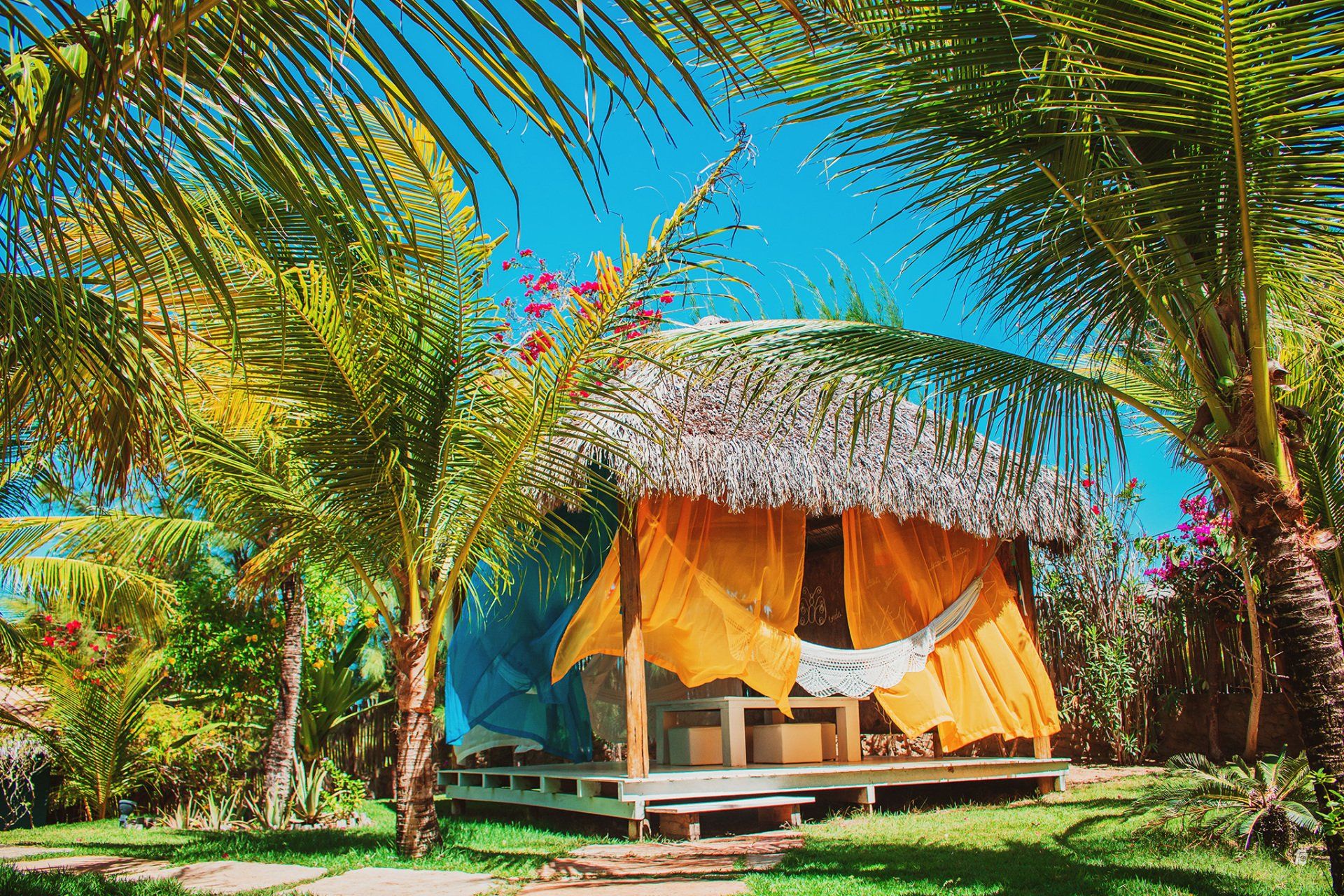 Uma pequena cabana com telhado de palha cercada por palmeiras.