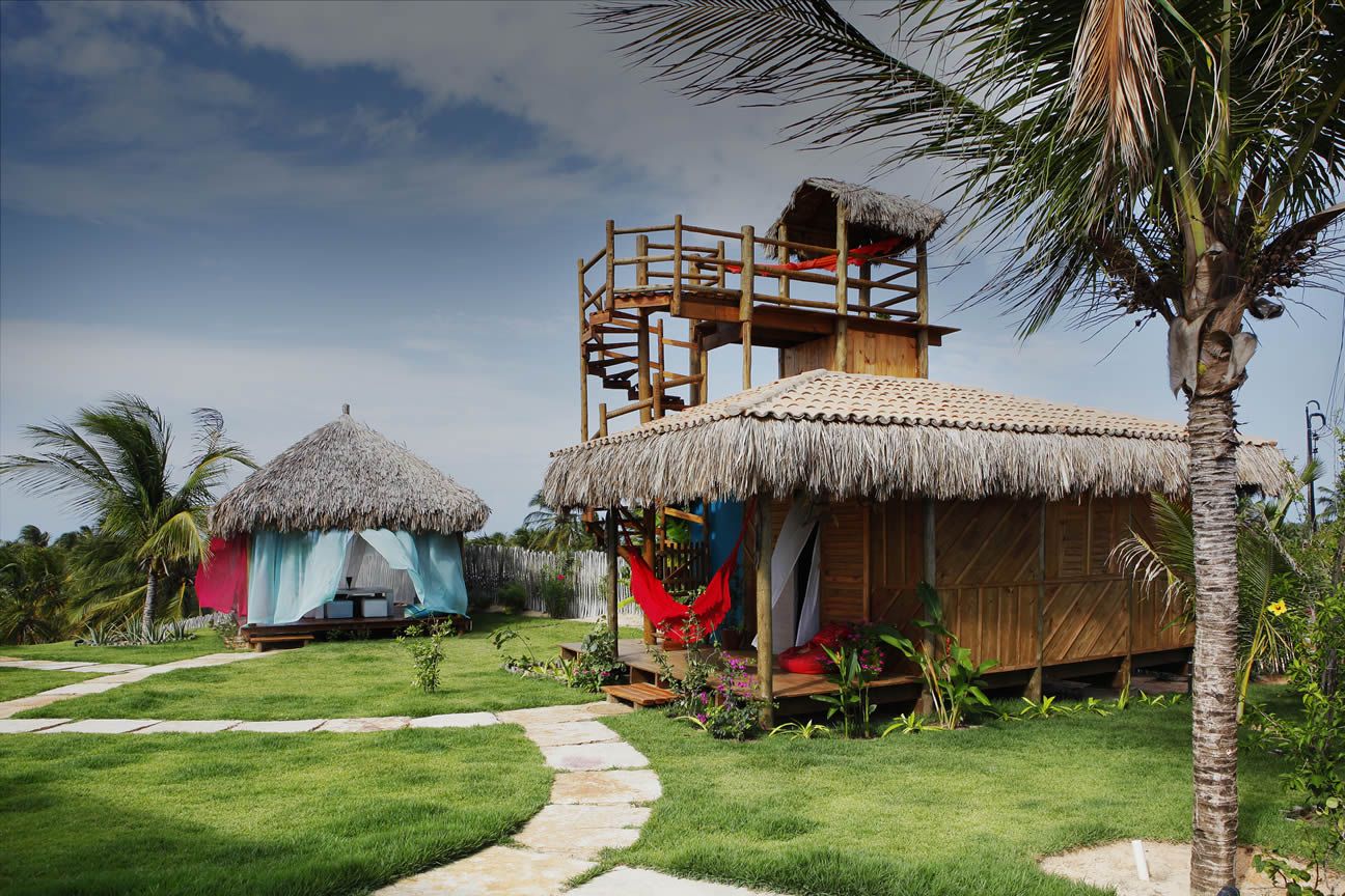 Uma cabana de palha com uma rede vermelha na frente