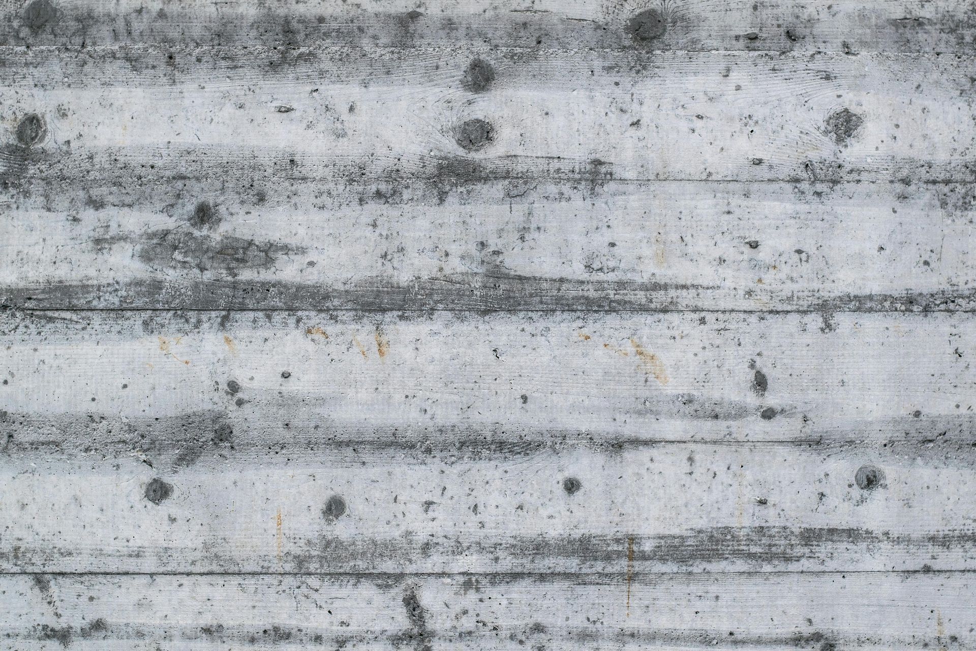 A close up of a concrete wall with holes in it.