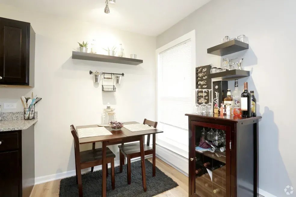 A dining room with a table and chairs and a bar.