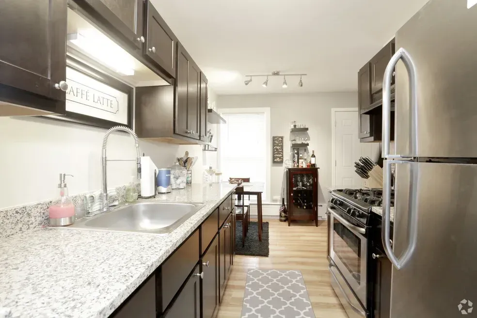 A kitchen with stainless steel appliances and granite counter tops.