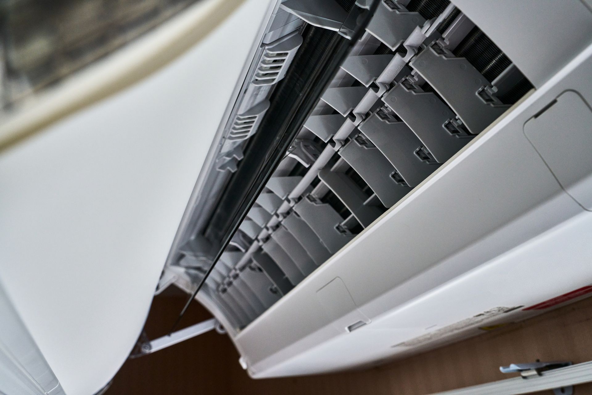 Air conditioner mounted on a wall, blowing refreshing cool air into a room.