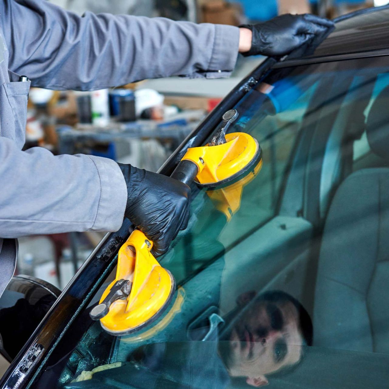 Repairman replaces windshield of car in workshop garage — San Antonio, TX — Rockguard Autoglass