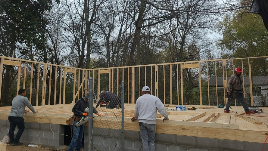 A group of men are working on a house under construction.