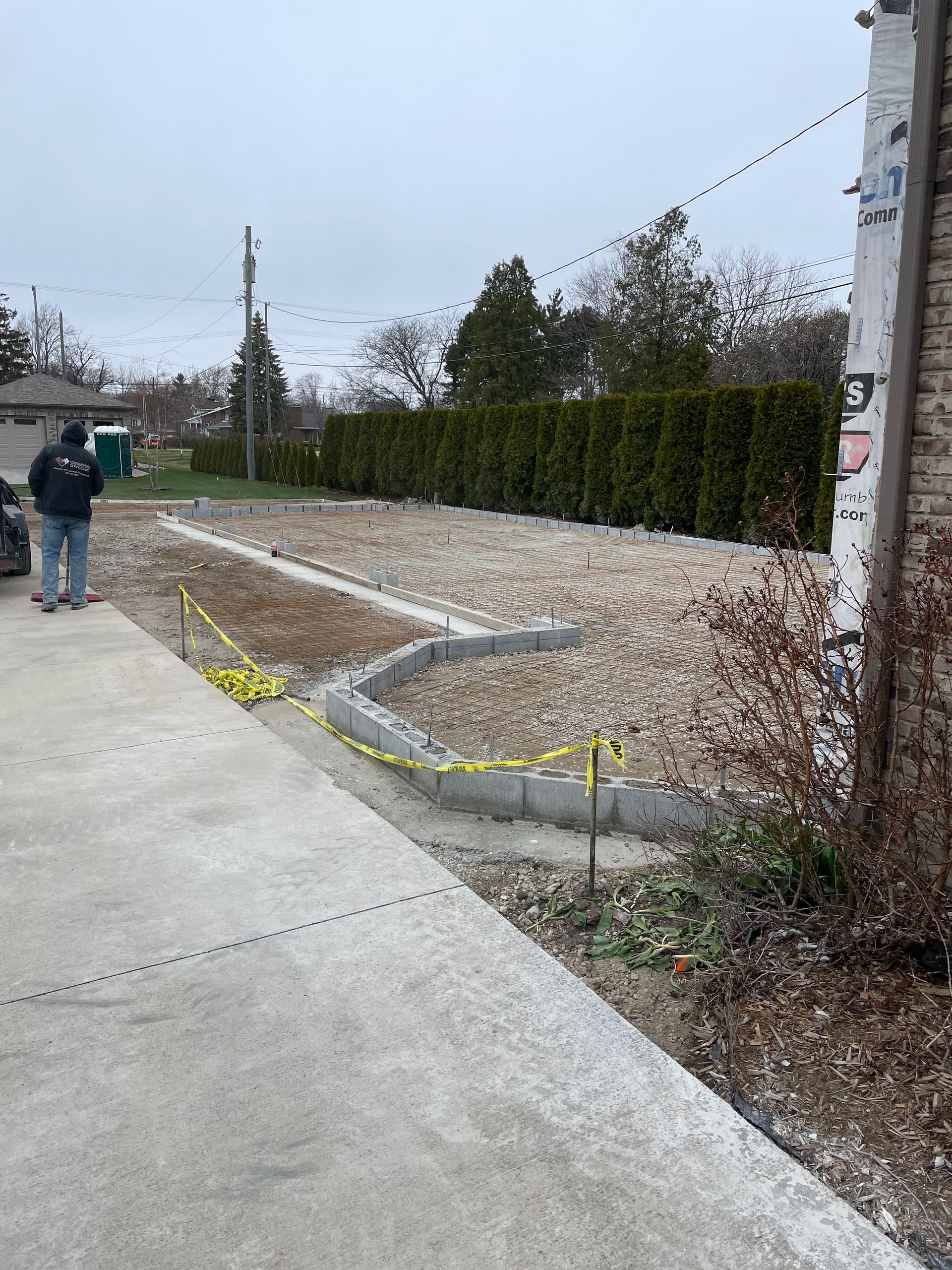 A couple of men standing on a sidewalk next to a brick building.