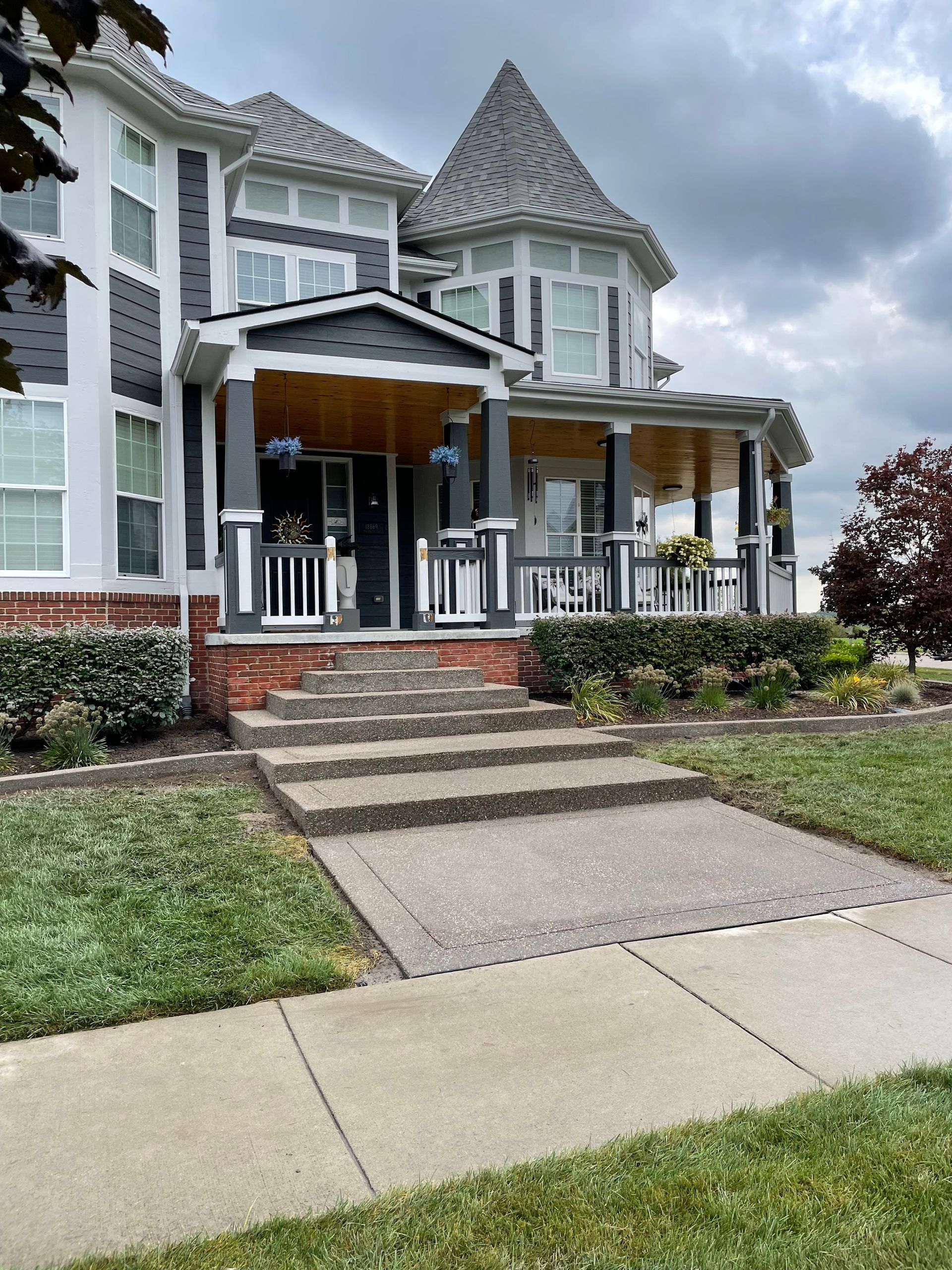 A large house with a porch and stairs leading up to it