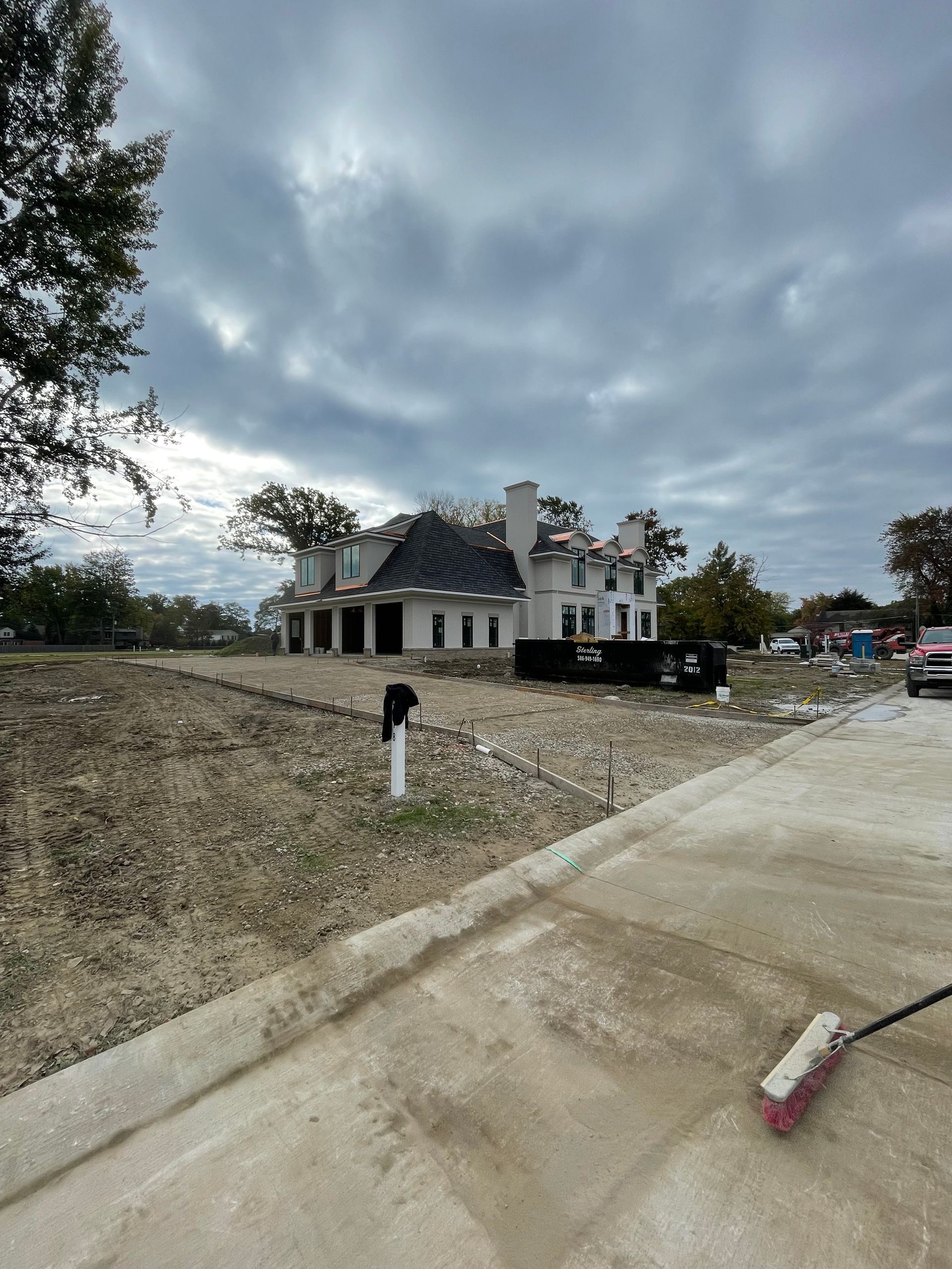 A large house is being built on a dirt lot