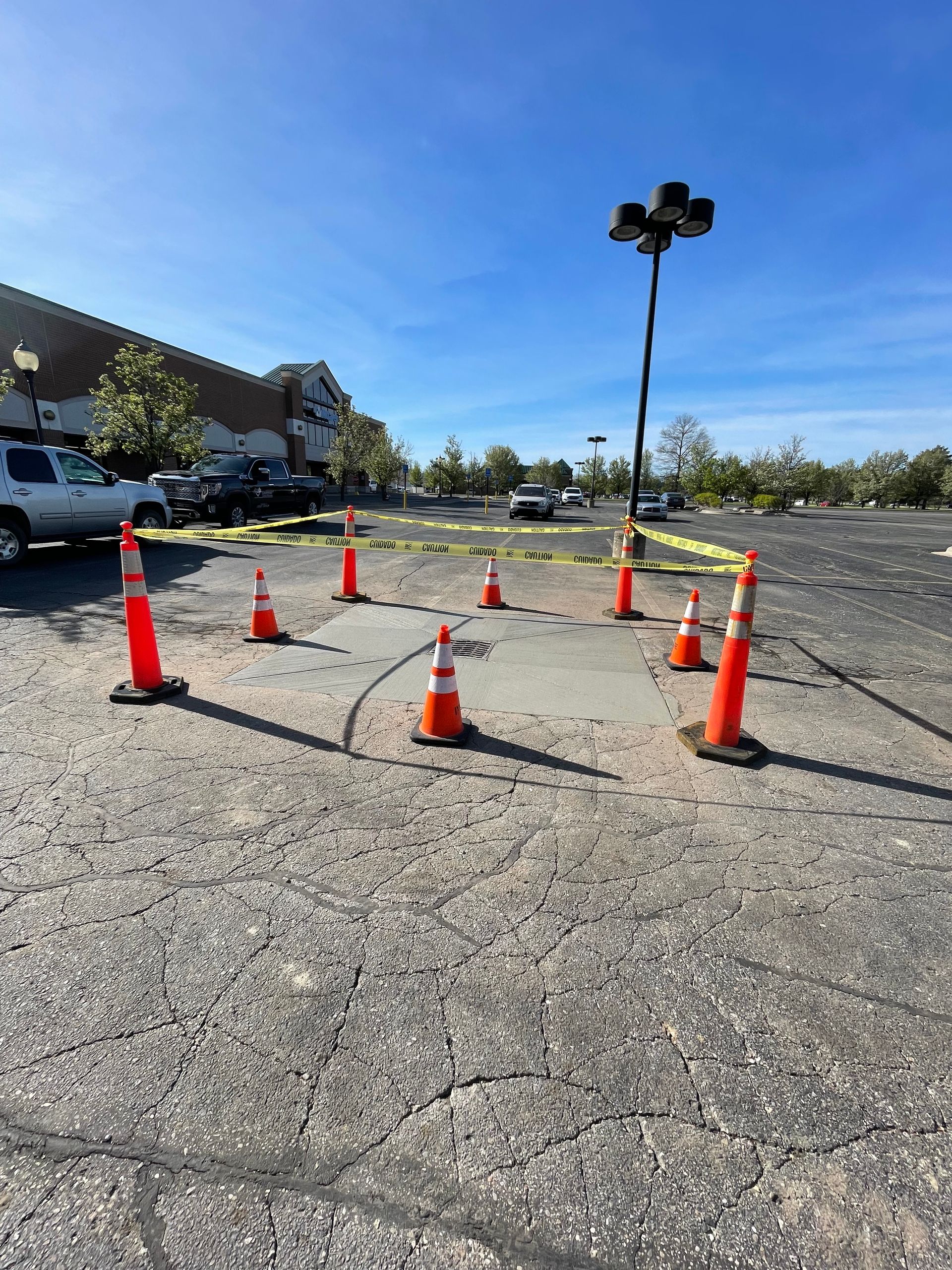 A parking lot with orange cones and yellow tape.