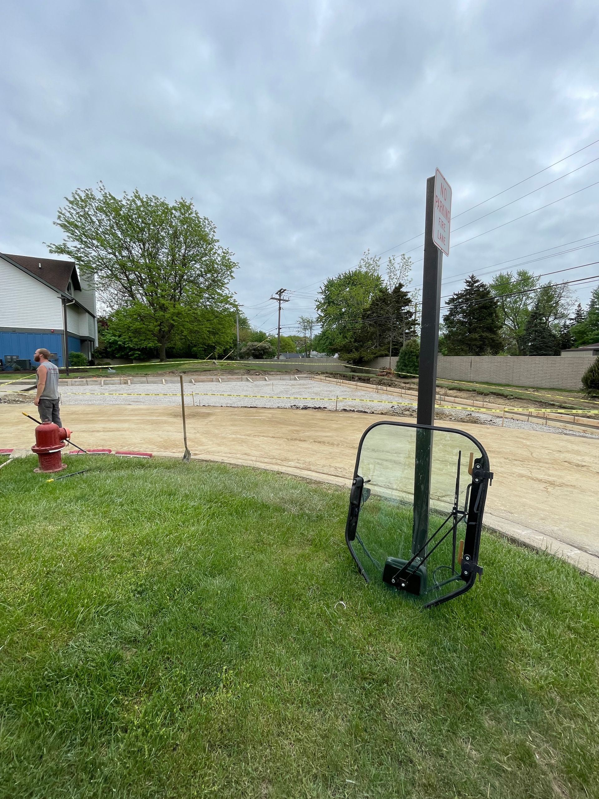 A broken windshield is sitting in the grass next to a fire hydrant.