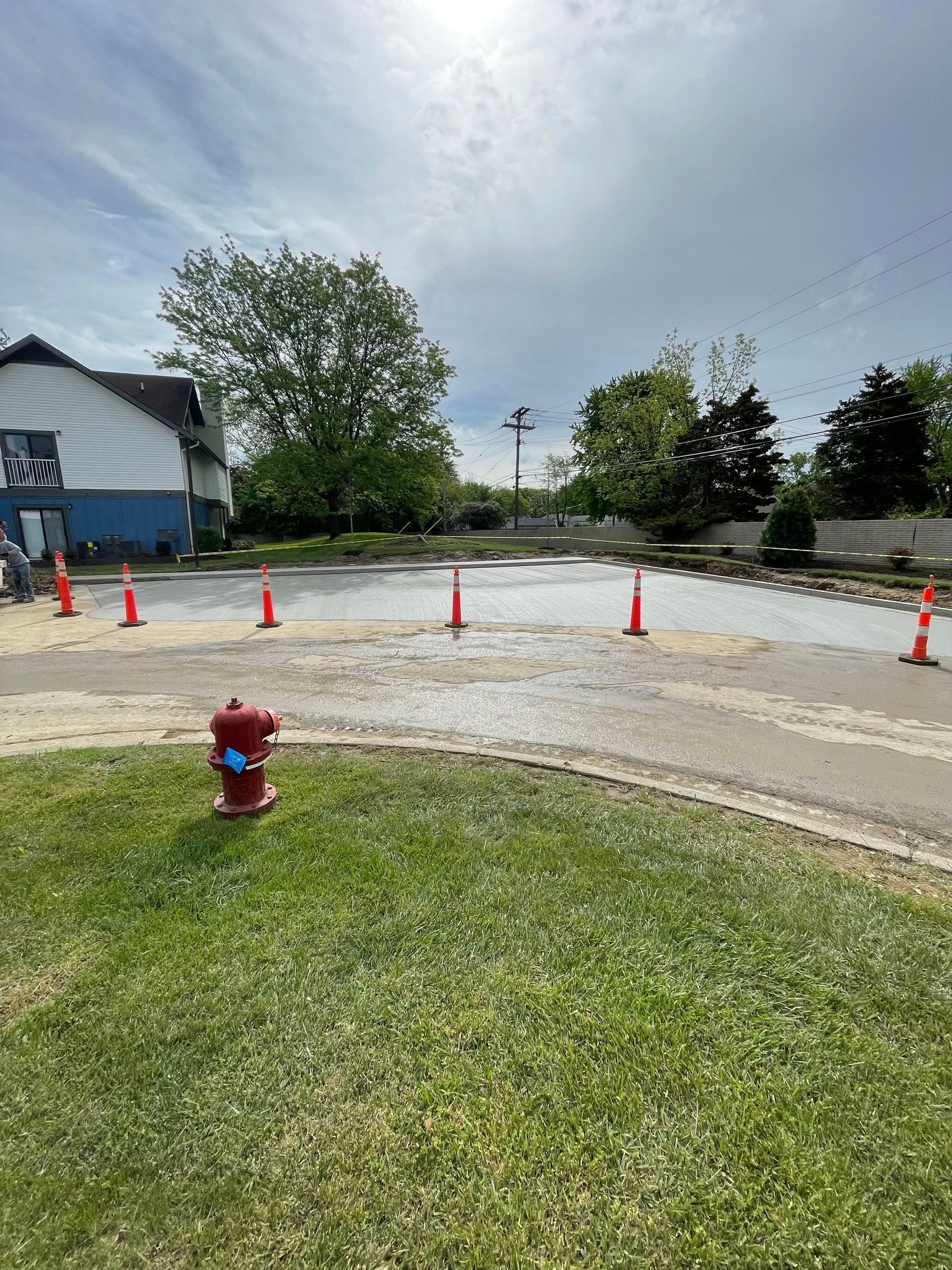 A red fire hydrant is in the middle of a flooded parking lot.