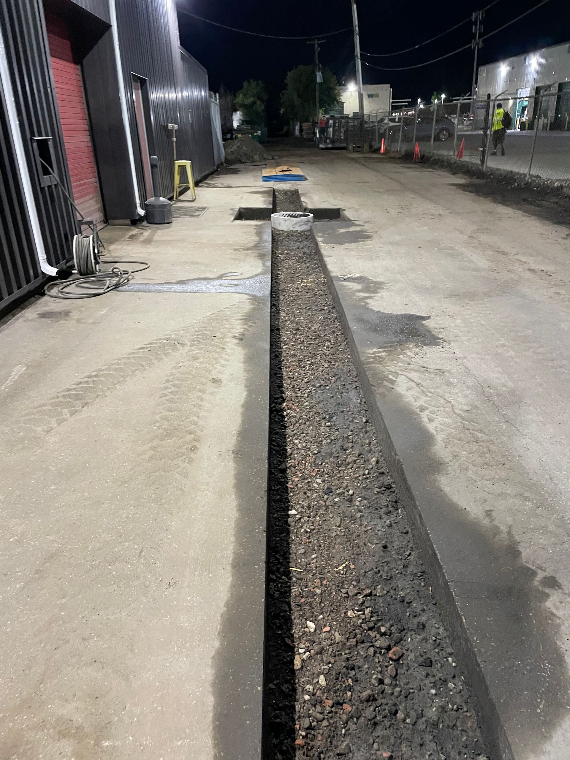 A drain is being installed on the side of a road.