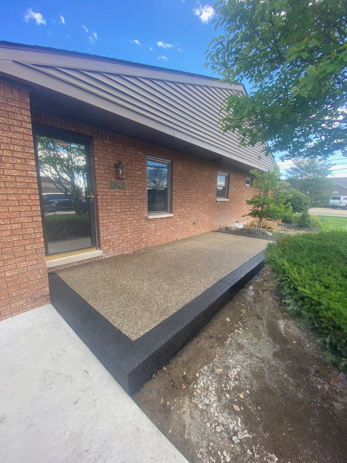 A brick building with a concrete walkway in front of it.