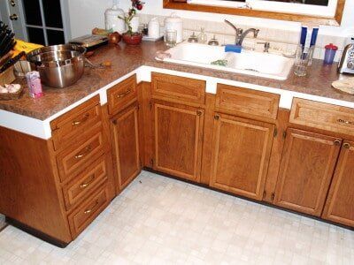 Brown kitchen cabinets with drawers and doors, a countertop, and a sink.