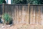 Wooden fence with weathering and discoloration.