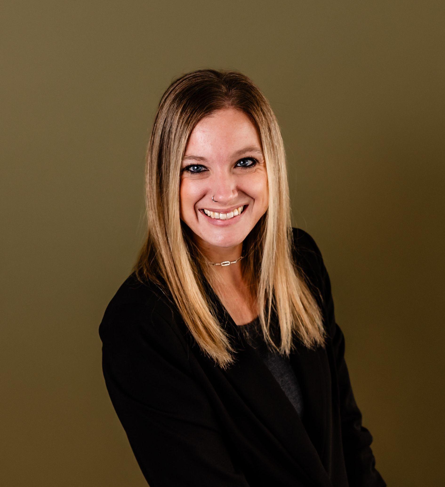 Agent Amanda Ferguson is wearing a black jacket and smiling for the camera.