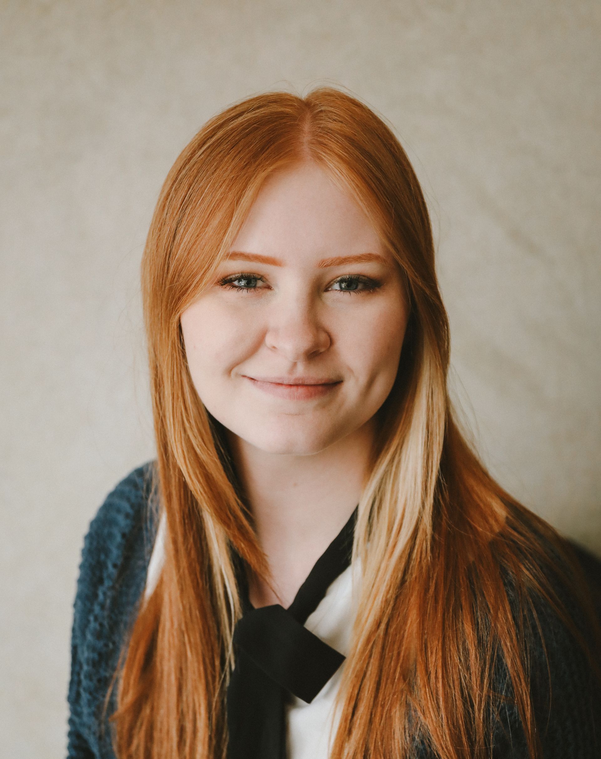 Team member Kaitlyn Blackstone is wearing a sweater and blouse and smiling.