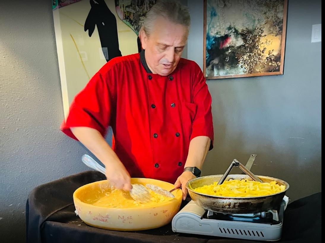 A man in a red shirt is preparing food on a table