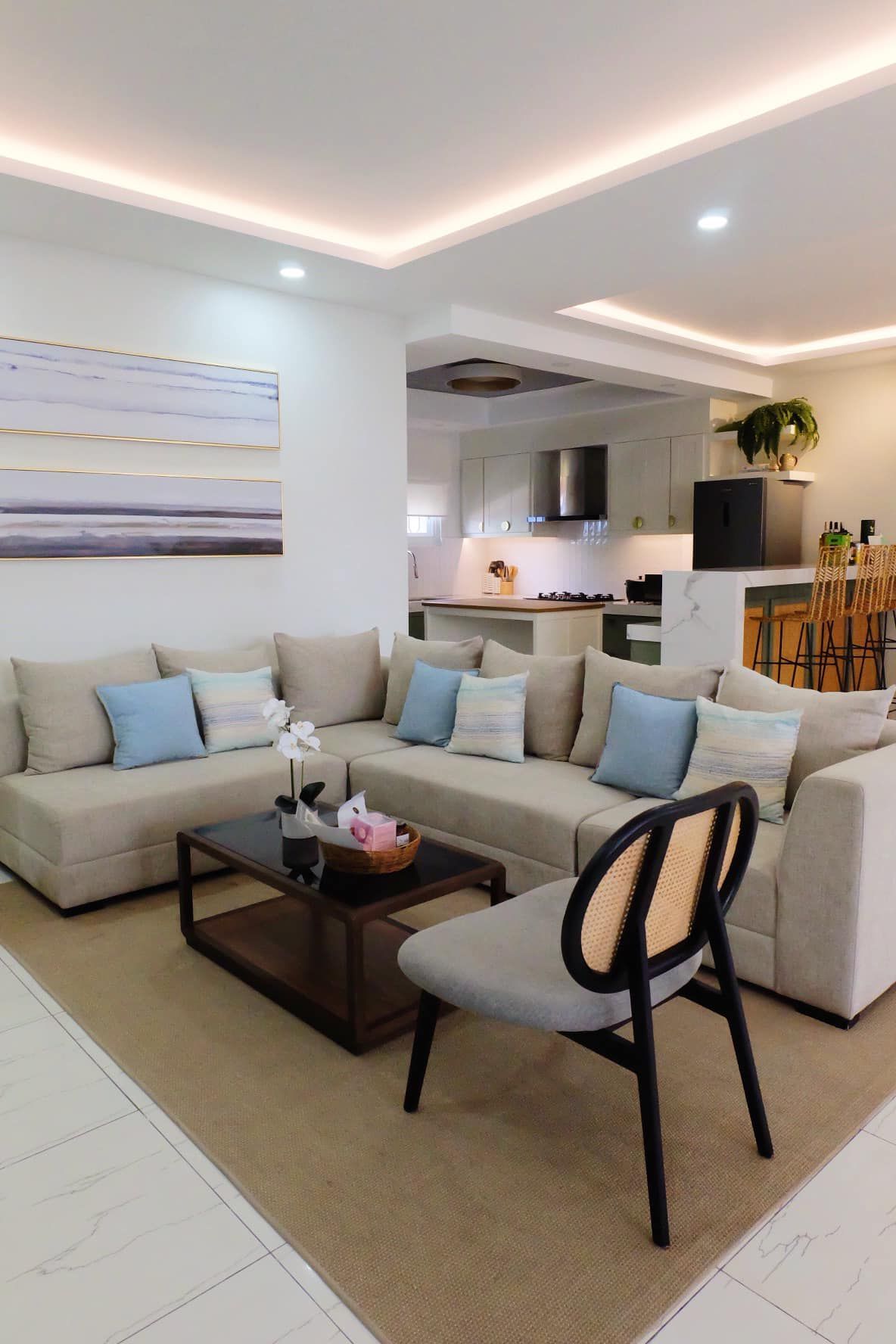 Spacious living room with a sectional sofa, coffee table, and open kitchen in the background.