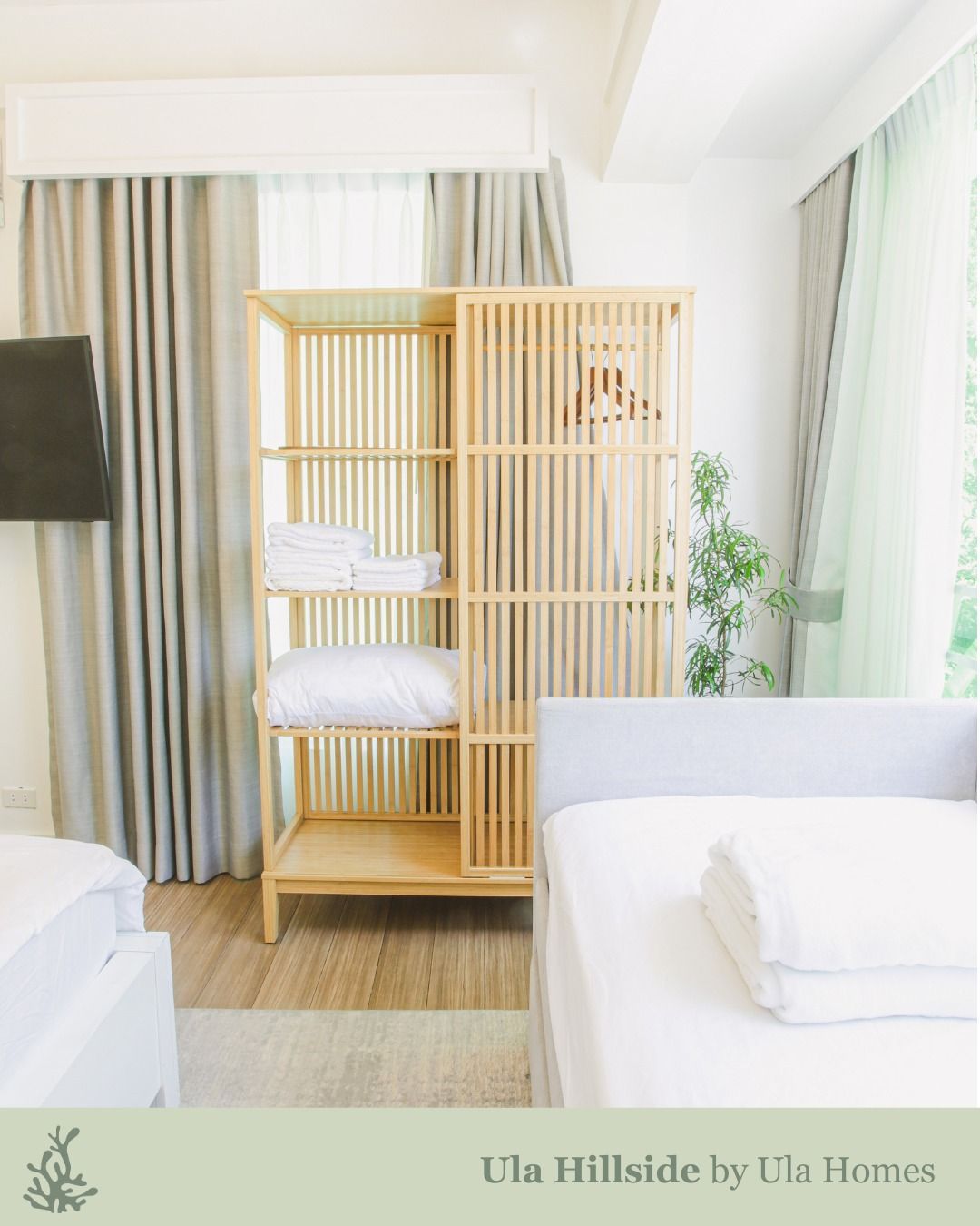 Wooden storage unit in a bedroom with bedding, soft colors.