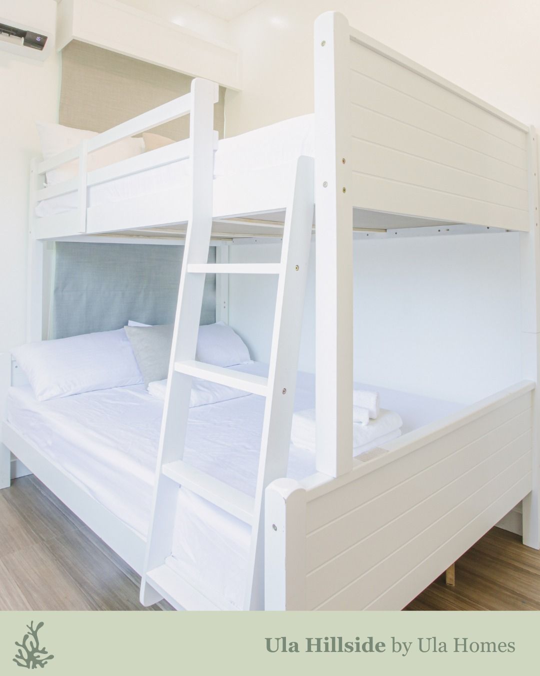 White bunk bed in a bedroom. Ladder to top bunk.