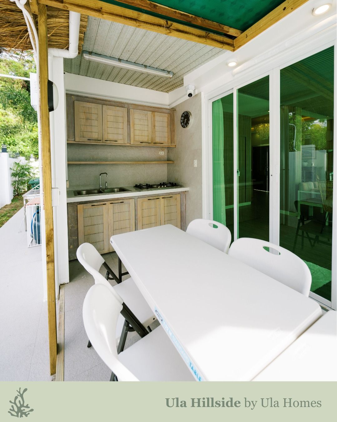 Outdoor kitchen with cabinets, stove, and a white table set for six.