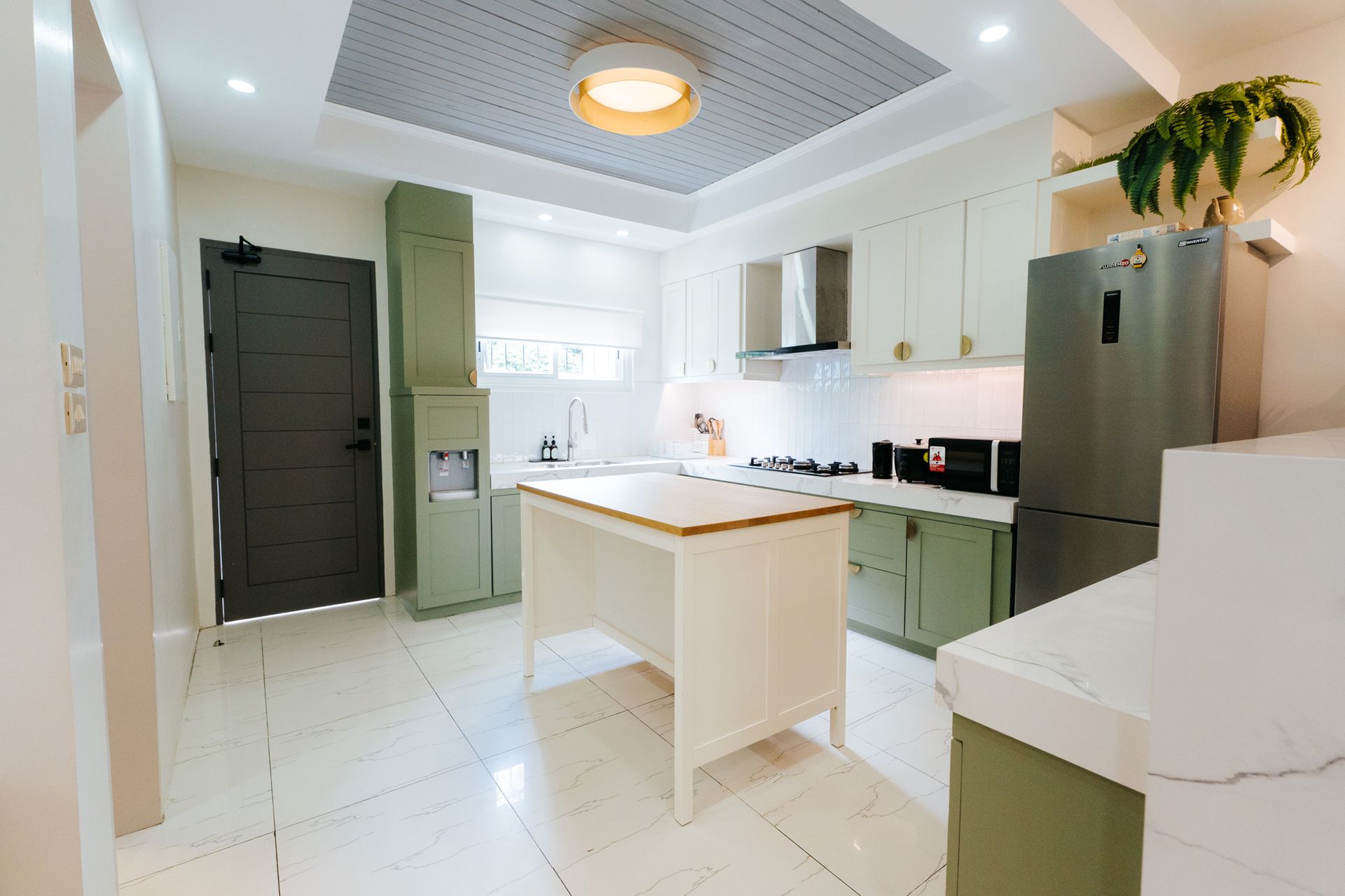Bright kitchen with white cabinets, light green accents, and a central island.