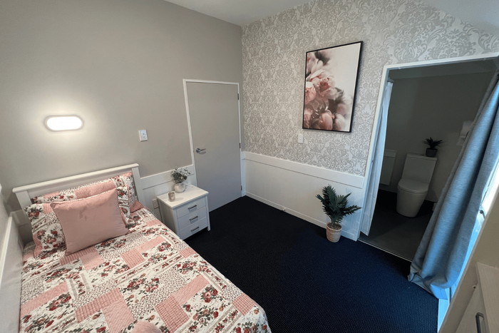 a bedroom with a window looking out to a garden