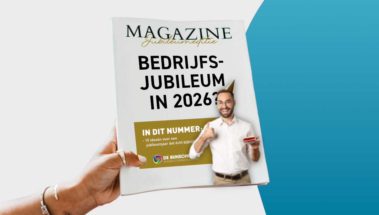 Een tijdschriftomslag over een bedrijfsjubileum in 2026, in de hand gehouden. Een man glimlacht en houdt een voorwerp vast.