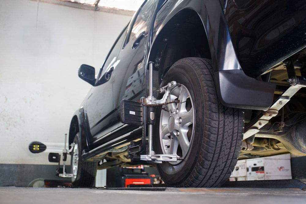 A Black Vehicle Undergoing a Wheel Alignment — Berkeley Vale Tyre & Mechanical in Fountaindale, NSW