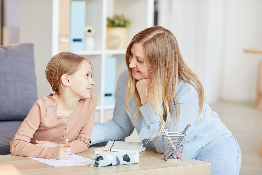 Therapist smiling and talking with child during ABA therapy session