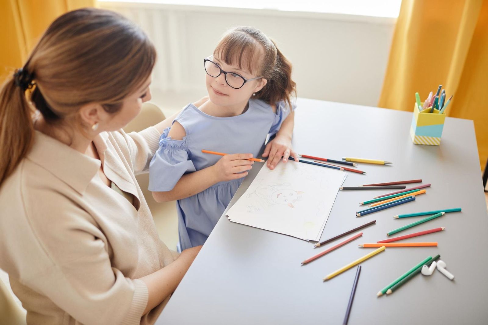 ABA therapist working with young girl during autism therapy session