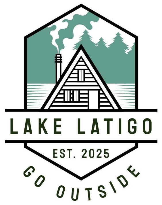 A logo featuring an A-frame cabin, pine trees, and smoke, with text reading "LAKE LATIGO", "EST. 2025", and "GO OUTSIDE".