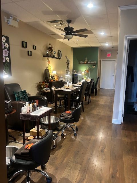 Interior of a nail salon with manicure tables, pedicure chairs, and decor.