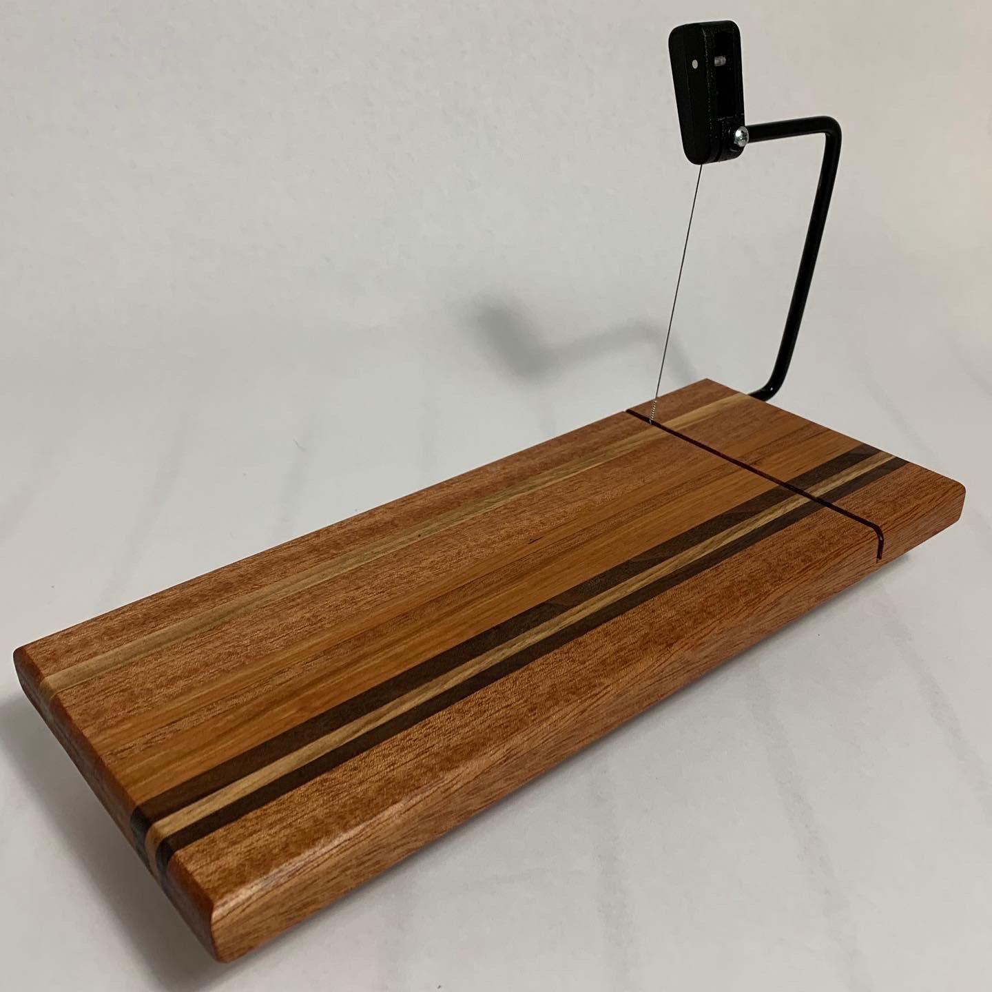 A wooden cutting board with a metal holder attached to it