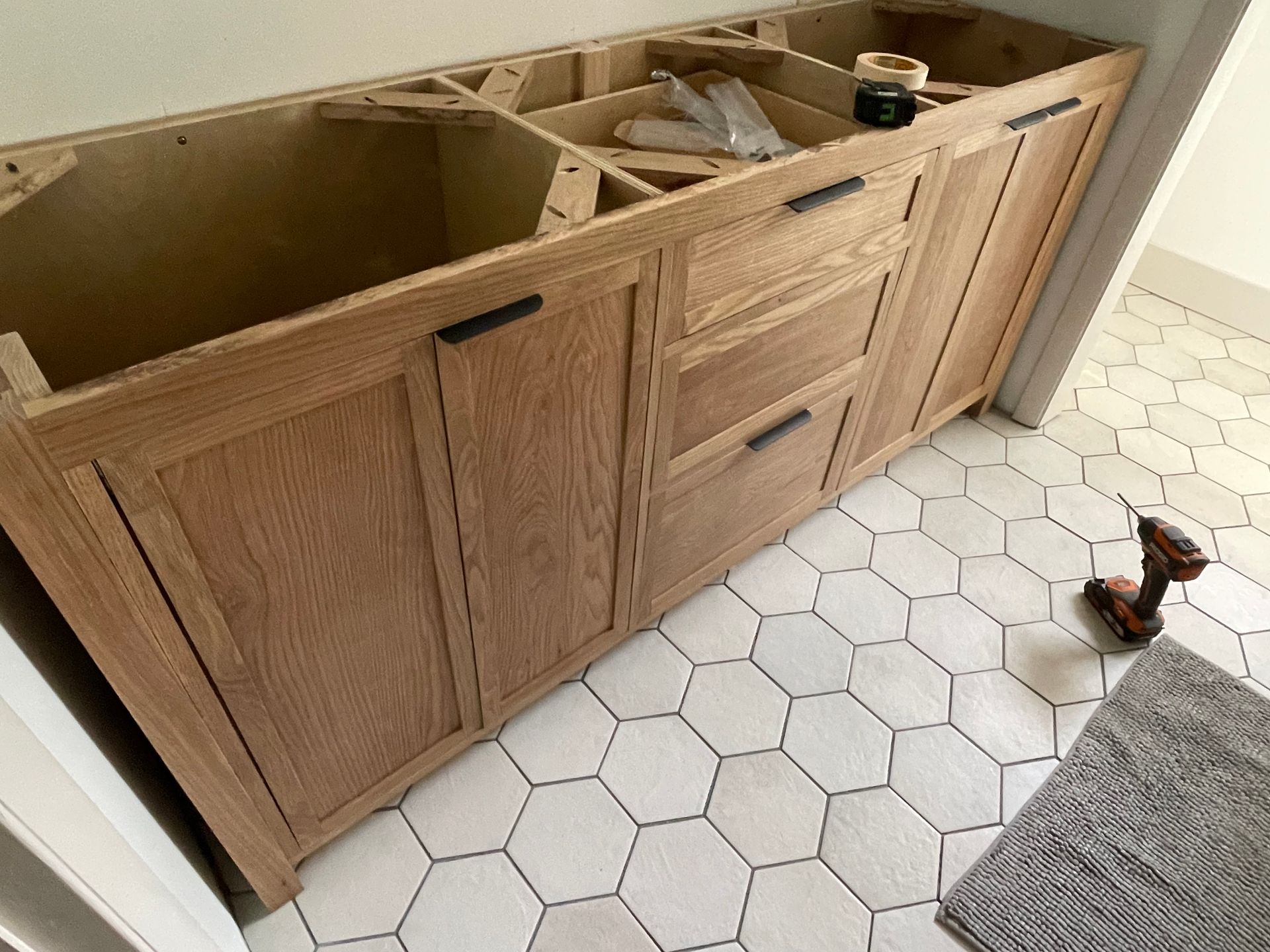 A wooden cabinet is being built in a bathroom.